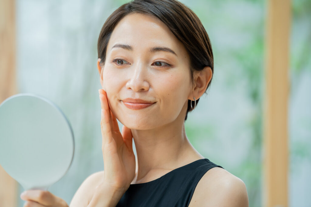 鏡を持ち肌の調子を実感する女性